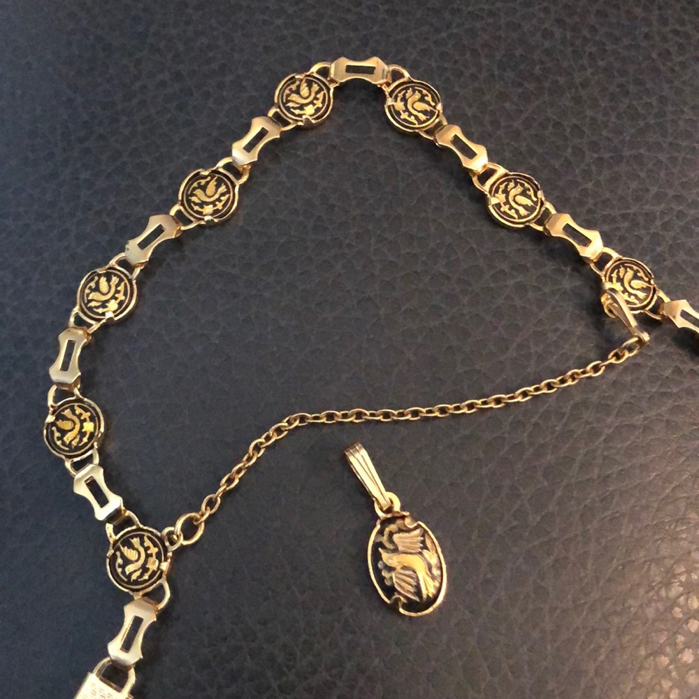 Gold bracket w/ black bird and a necklace